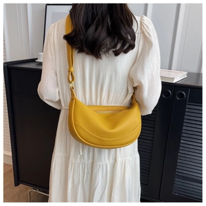 Detailed view of yellow half-moon saddle bag with pebble texture and adjustable strap