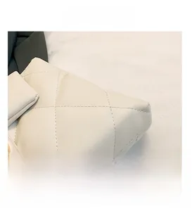 Close-up of quilted diamond pattern and fine stitching on a beige luxury tote bag