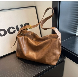 Detail van de bruine vintage hobo tas textuur met gouden metalen gesp op de schouderband