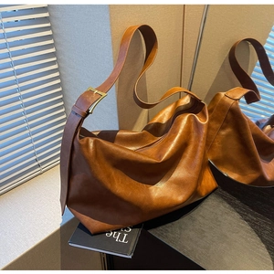 Detail van vintage bruine hobo-tas met gouden gesp en zachte leertextuur