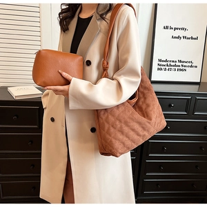 Brown quilted suede tote bag and small pouch set shown with a model in modern interior