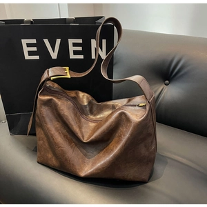 Detail van donkerbruine leren shopper met vintage textuur en gouden metalen gesp