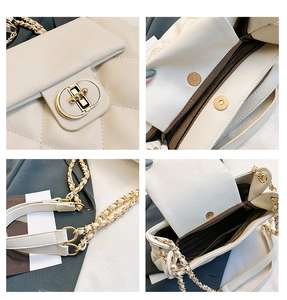 Detail view of white quilted handbag featuring gold metal lock and chain strap