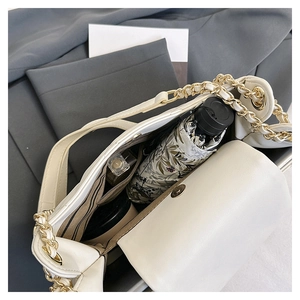 Detail view of large white chain tote bag interior with umbrella and cosmetic storage
