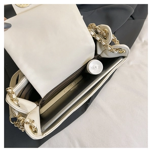 Detail view of the spacious inner compartments of the cream leather chain bag