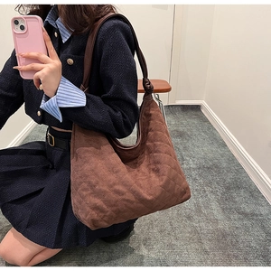 Close-up of brown quilted dumpling bag featuring knot detail and textured suede finish