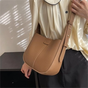 Brown litchi leather bucket bag with gold hardware and wide shoulder strap for women