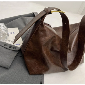 Detail van de donkerbruine shopper met verouderde ledertextuur en gouden metalen gesp