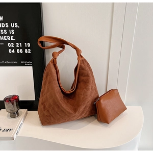 Detail of brown quilted hobo bag with knotted strap and matching zipper pouch