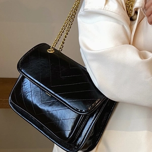 Chic black chevron quilted chain shoulder bag with gold hardware for women