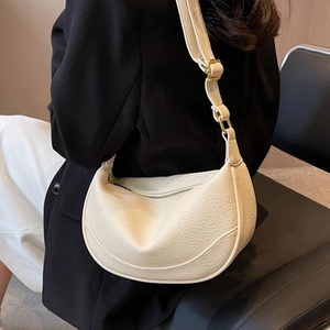 Minimalist beige hobo bag in grainy leather with adjustable gold buckle shoulder strap