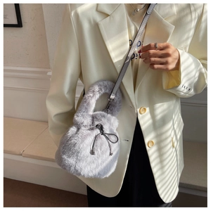 Detail of grey faux fur bucket bag featuring drawstring closure and silver hardware
