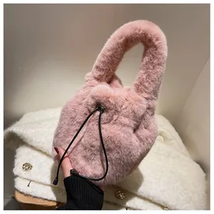 Detailed view of pink plush bucket bag with soft faux fur texture and black drawstring closure