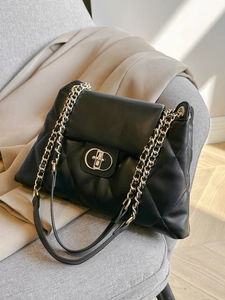 Classic black quilted leather tote bag with large diamond stitching and chain strap