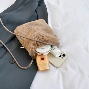 Internal capacity of brown plush crossbody bag showing space for phone and makeup