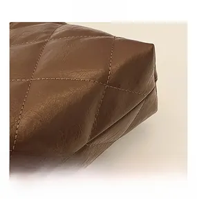 Close-up of dark brown leather quilted texture and fine stitching on the bag