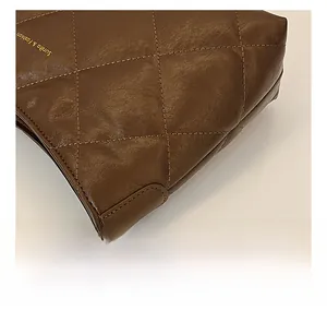 Detail of brown quilted faux leather texture and gold chain strap on shoulder bag