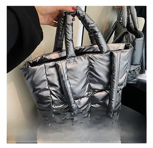 Detailed close-up of metallic silver quilted puffer tote bag with dual carrying handles