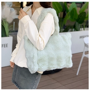 Gros plan d'un sac cabas en fausse fourrure vert menthe montrant sa texture douce et large