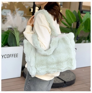 Détail d'un sac cabas en peluche vert menthe doux porté par un mannequin en extérieur