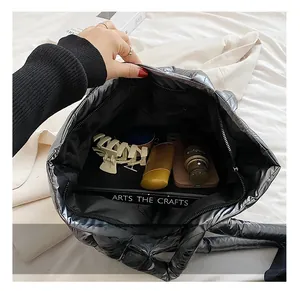 Macro shot showing the spacious interior of a black quilted tote with daily essentials