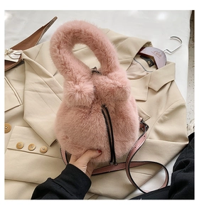 Detail of pink plush bucket bag featuring drawstring closure and faux fur texture