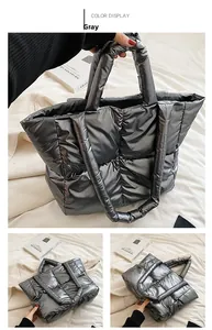 Detail of silver quilted puffer tote bag with high-shine finish and twin top handles