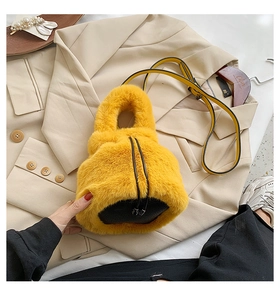 Detail of yellow faux fur bucket bag featuring plush texture and adjustable shoulder strap