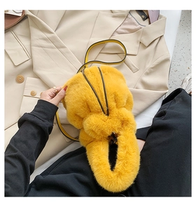 Close-up of fluffy yellow plush bucket bag with contrasting black leather shoulder strap