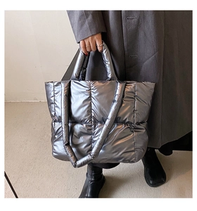 Detailed view of metallic silver quilted tote bag with high-gloss nylon texture