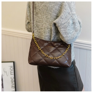 Close-up of brown quilted crossbody bag with gold chain and long shoulder strap details