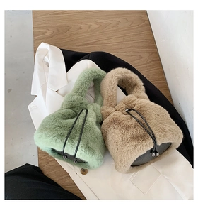 Top view of plush bucket bags in mint green and beige with black drawstrings