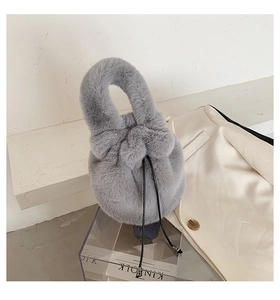 Detail of plush grey faux fur bucket bag with soft texture and drawstring closure