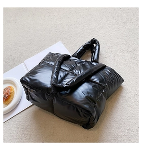 Glossy black quilted puffer tote bag with high-shine nylon fabric and thick handles