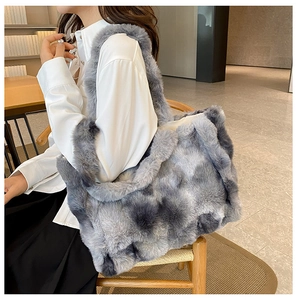 Détail d'un grand sac fourre-tout en fausse fourrure grise et blanche porté par un mannequin