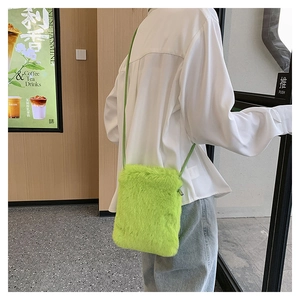 Fluorescent green plush crossbody bag shown on a model in a cozy coffee shop interior