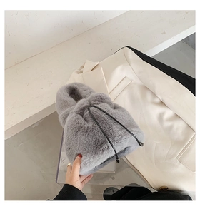 Close-up of grey faux fur bucket bag with drawstring closure and soft plush texture
