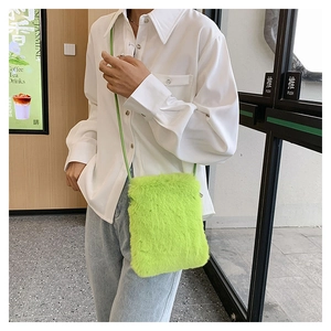 Detail of light green plush faux fur texture and soft crossbody strap on small phone bag