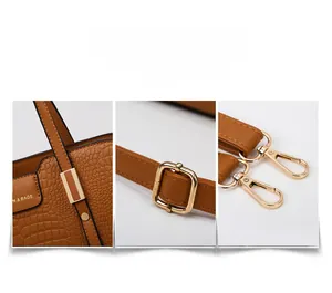 Detail of brown crocodile pattern handbag featuring gold logo plate and precision stitching