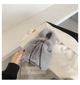 Close-up of grey faux fur bucket bag showing soft plush texture and drawstring closure