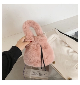 Detailed close-up of pink faux fur bucket bag with black drawstring closure and soft texture