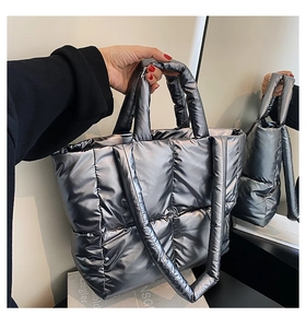 Detailed view of large metallic silver quilted tote bag with padded handles and strap