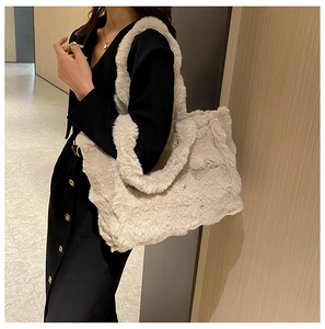 Gros plan d'un grand sac cabas en peluche crème porté par un mannequin dans un intérieur