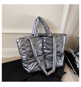 Detail of silver metallic quilted tote bag featuring padded puffer diamond stitching