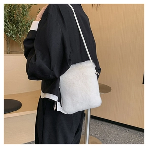 Detail shot of a soft white plush crossbody bag showcasing its fluffy faux fur texture