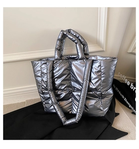 Macro shot of silver metallic padded tote bag showing high-shine texture and quilted fabric