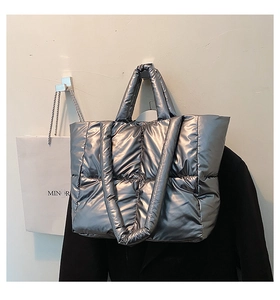 Macro shot of silver quilted puffer tote bag with metallic finish and soft padded straps