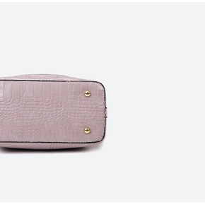 Detail of lavender crocodile-embossed leather handbag with protective gold metal feet