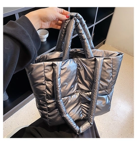 Detail showing the silver metallic quilted texture and stitching of the large tote bag