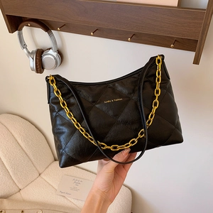 Quilted black leather handbag with gold chain strap and spacious interior for daily commute